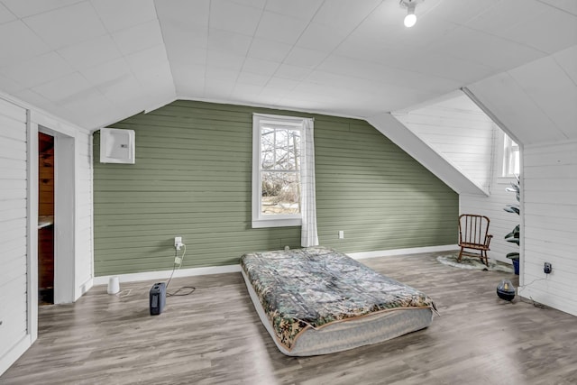 sitting room featuring wood-type flooring, wood walls, and lofted ceiling