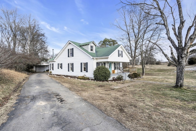 view of front of house with covered porch, an outbuilding, and a garage