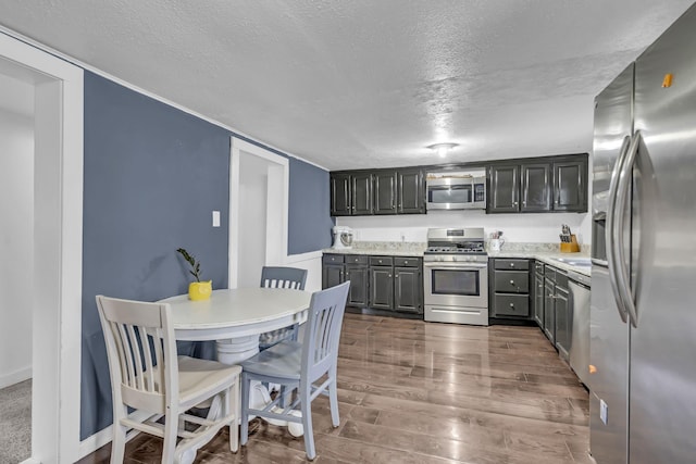 kitchen with stainless steel appliances, dark hardwood / wood-style flooring, and a textured ceiling