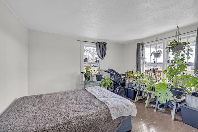 bedroom featuring hardwood / wood-style floors and a textured ceiling