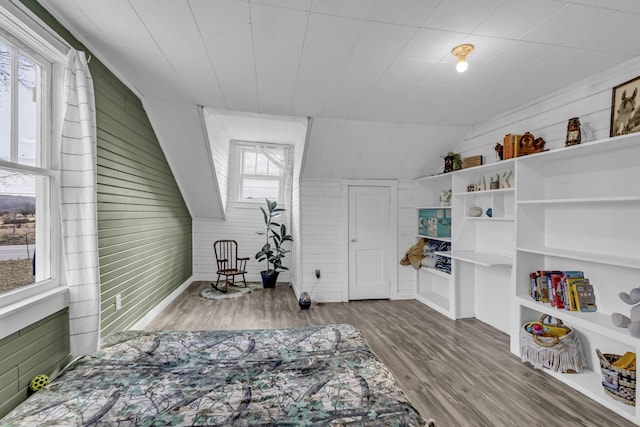 interior space with plenty of natural light, wood-type flooring, and wood walls