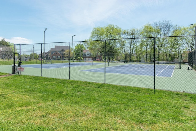 view of tennis court featuring a yard