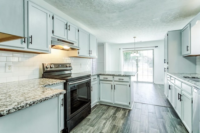 kitchen featuring hanging light fixtures, stainless steel electric range oven, light stone counters, and kitchen peninsula