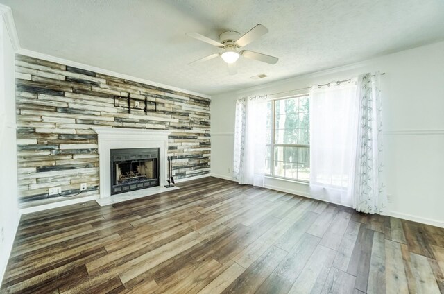 unfurnished living room featuring ceiling fan, a large fireplace, hardwood / wood-style floors, and a textured ceiling