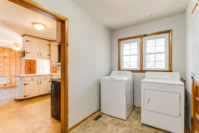 clothes washing area with ceiling fan, a wealth of natural light, and washing machine and clothes dryer