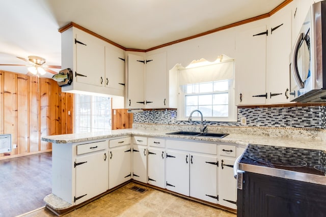 kitchen with white cabinetry, kitchen peninsula, ceiling fan, stainless steel appliances, and sink