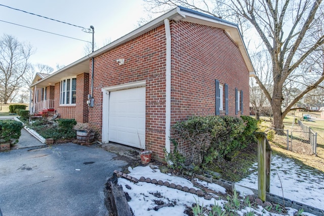 view of snow covered exterior with a garage