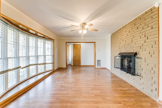 unfurnished living room with ceiling fan, a fireplace, crown molding, and light hardwood / wood-style flooring