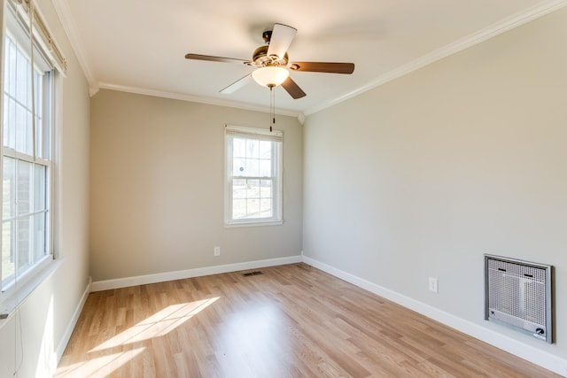 spare room with heating unit, light wood-type flooring, and crown molding