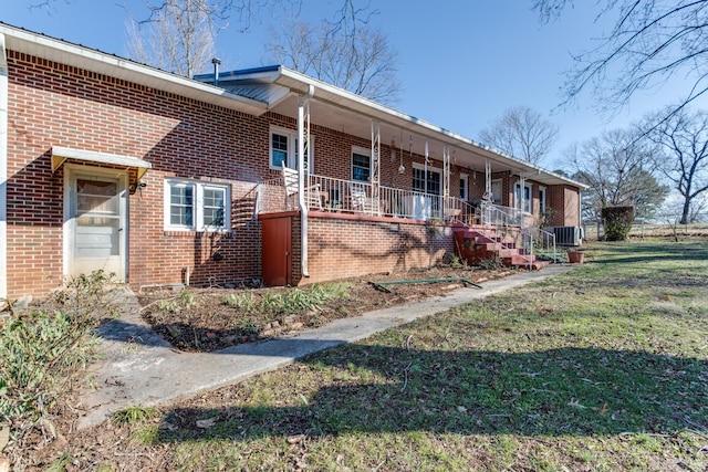 view of front of property featuring a front lawn, a porch, and central air condition unit