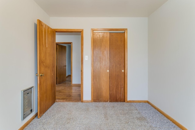 unfurnished bedroom with light carpet and a closet