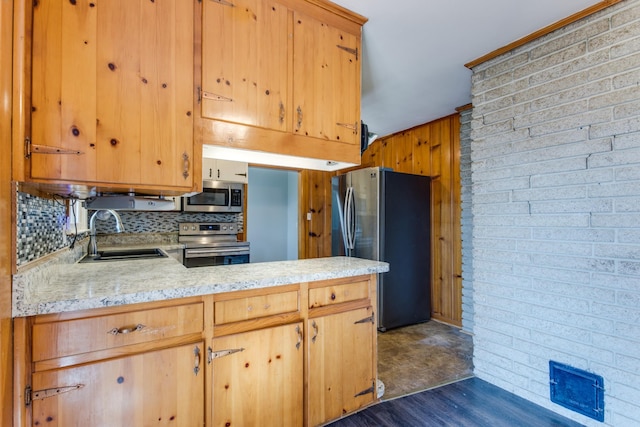 kitchen with backsplash, kitchen peninsula, sink, stainless steel appliances, and dark hardwood / wood-style flooring