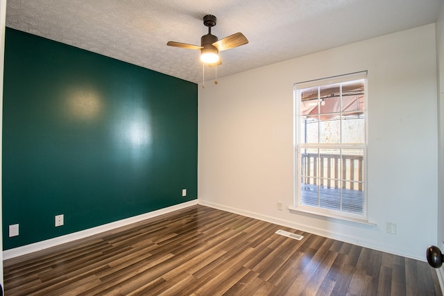 spare room featuring dark hardwood / wood-style flooring, ceiling fan, and a textured ceiling