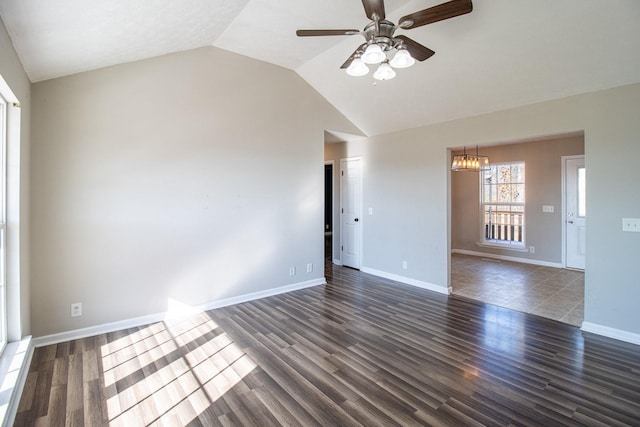 unfurnished living room featuring lofted ceiling, dark hardwood / wood-style floors, and ceiling fan with notable chandelier