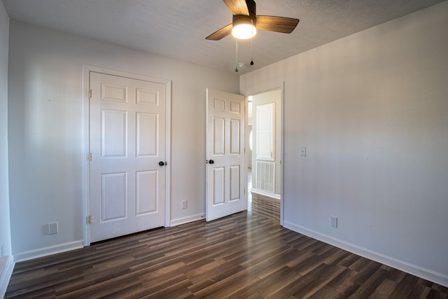 unfurnished bedroom featuring dark wood-type flooring and ceiling fan