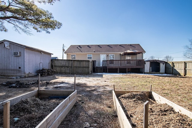 back of house featuring a lawn, a deck, and a storage shed