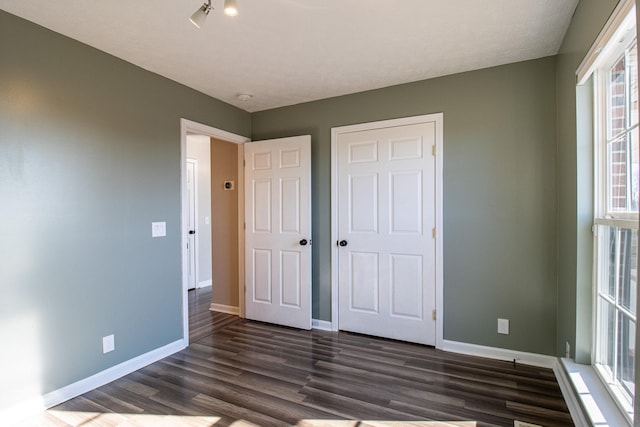 unfurnished bedroom featuring dark wood-type flooring