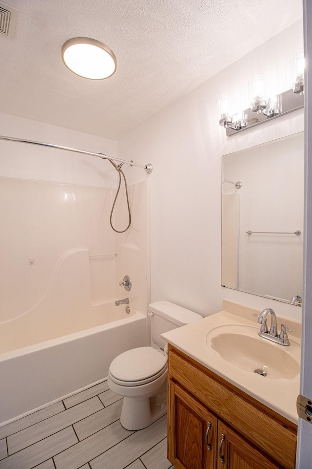 full bathroom with vanity, a textured ceiling, tub / shower combination, and toilet