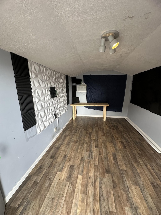 bonus room featuring hardwood / wood-style floors, vaulted ceiling, and a textured ceiling