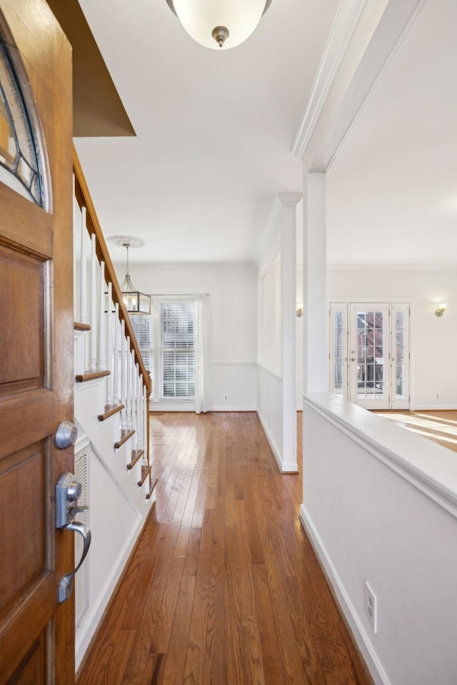 entrance foyer with a chandelier, ornamental molding, and hardwood / wood-style floors