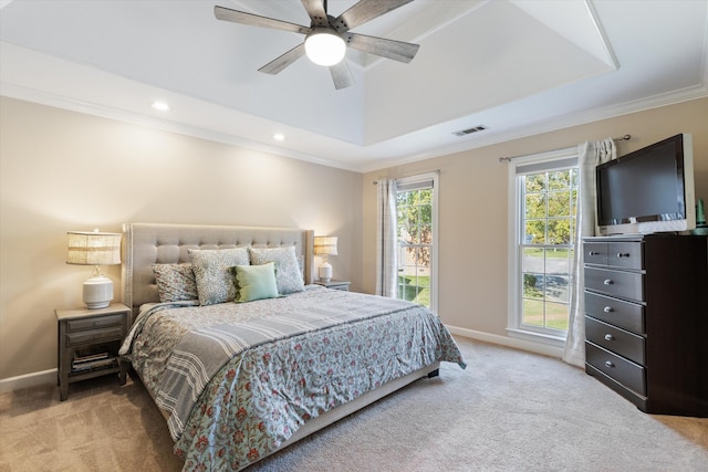 carpeted bedroom with ceiling fan, crown molding, and a tray ceiling