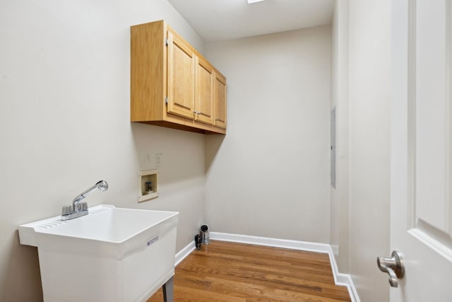 clothes washing area with washer hookup, cabinets, hardwood / wood-style flooring, and sink