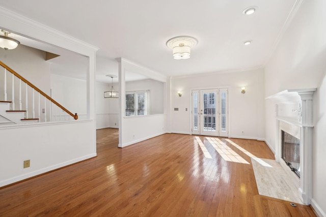 unfurnished living room featuring light wood-type flooring and ornamental molding