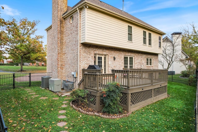 back of house featuring a wooden deck, a yard, and central air condition unit