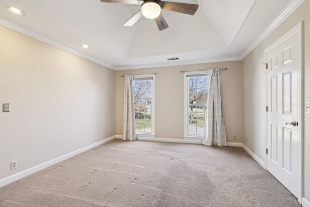 carpeted empty room with a raised ceiling, ceiling fan, and ornamental molding