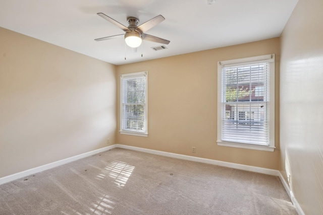 carpeted spare room featuring ceiling fan