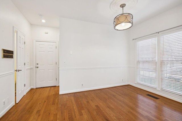 unfurnished room featuring a healthy amount of sunlight and hardwood / wood-style flooring