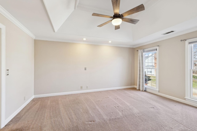 carpeted spare room featuring ceiling fan, ornamental molding, and a raised ceiling