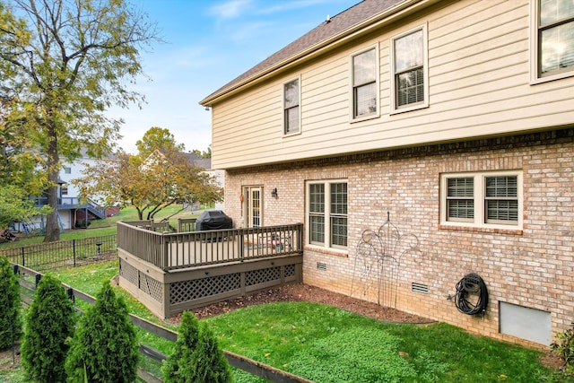 back of house featuring a wooden deck and a yard