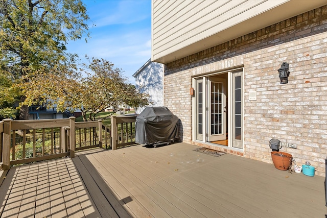 wooden deck featuring a grill