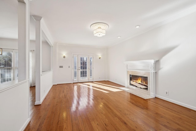 unfurnished living room with hardwood / wood-style flooring and crown molding