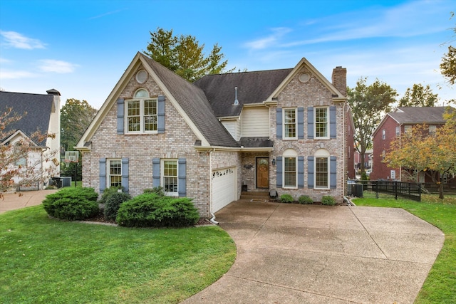 view of front of property with a front yard, central AC unit, and a garage