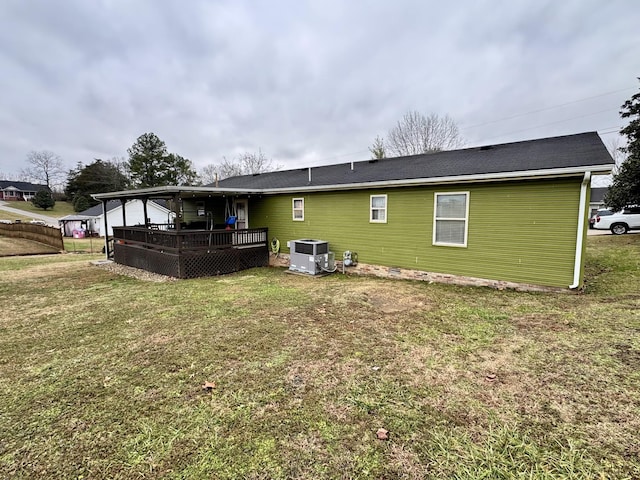 rear view of property with a wooden deck, central AC, and a lawn