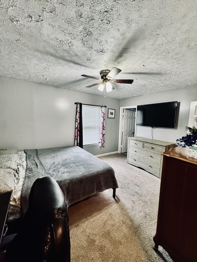 bedroom featuring ceiling fan, carpet, and a textured ceiling