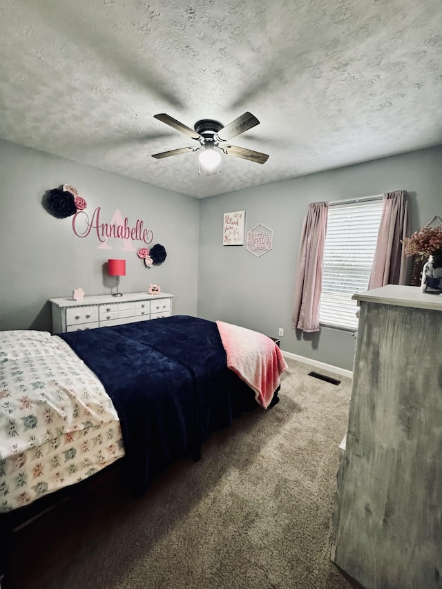 carpeted bedroom featuring ceiling fan and a textured ceiling