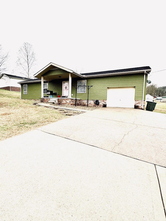 ranch-style house with covered porch, a garage, and a front lawn