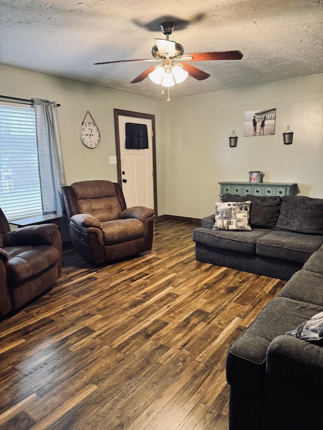 living room with a textured ceiling, ceiling fan, and dark hardwood / wood-style flooring