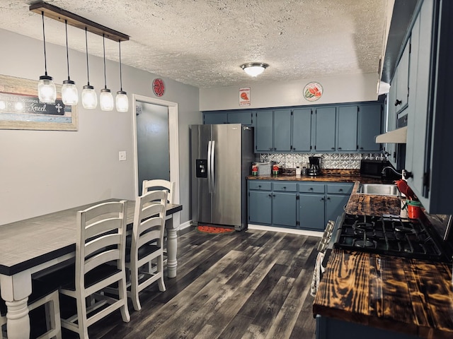 kitchen featuring pendant lighting, a textured ceiling, blue cabinetry, stainless steel fridge with ice dispenser, and butcher block countertops