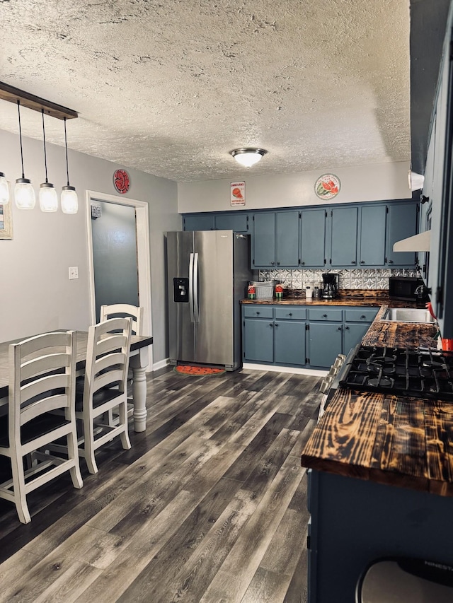 kitchen featuring stainless steel fridge with ice dispenser, decorative backsplash, blue cabinetry, a textured ceiling, and sink