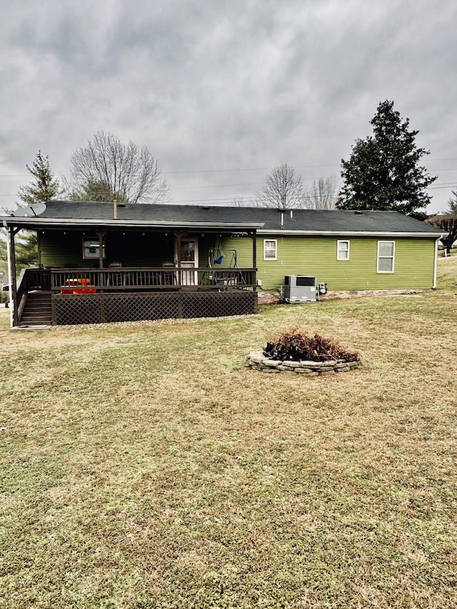 back of property featuring a wooden deck and a lawn