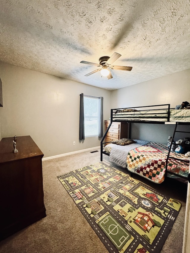 bedroom with ceiling fan, carpet, and a textured ceiling