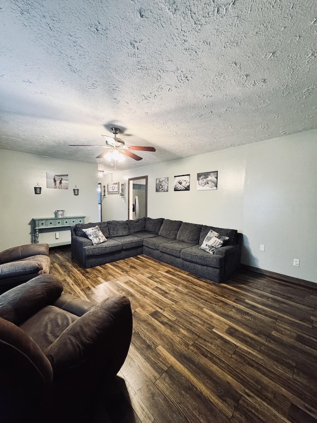 living room featuring ceiling fan, hardwood / wood-style floors, and a textured ceiling