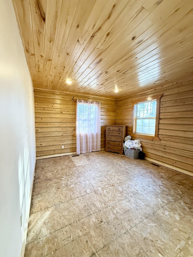 bonus room featuring a healthy amount of sunlight, wood ceiling, and wood walls