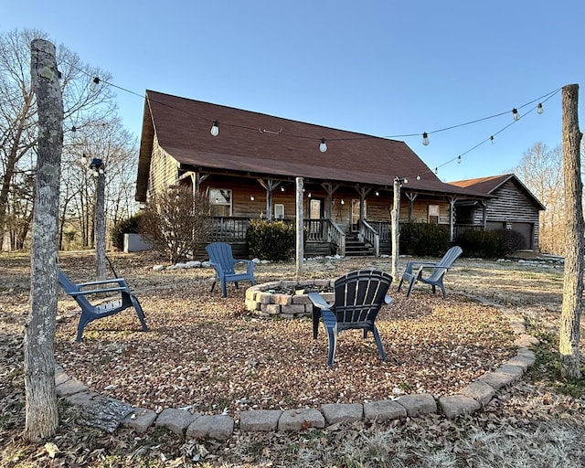 back of house featuring a porch and a fire pit