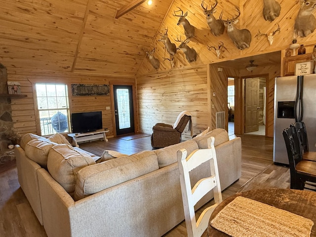 living room featuring hardwood / wood-style flooring, lofted ceiling with beams, wood ceiling, and wooden walls