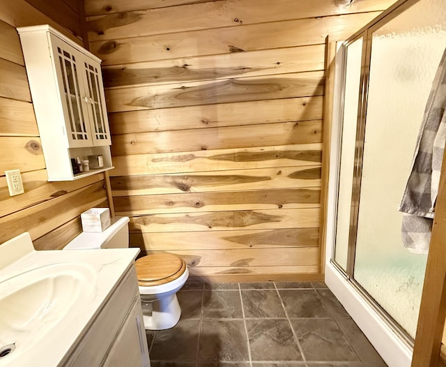 bathroom with toilet, vanity, and wood walls